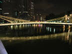 Cavenagh Bridge adjacent to Fullerton Hotel at night.