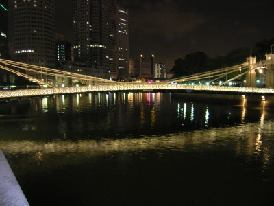 Cavenagh Bridge adjacent to Fullerton Hotel at night.