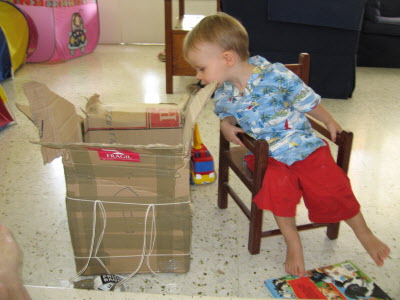 Conrad checking there are no more goodies in the box containg the chair made for him by Grandpa Burton.