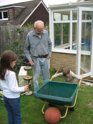 Conrad and Lottie helping Grandpa Burton in the garden.