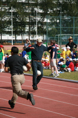 Daddy runnning with a rugby ball between his legs.