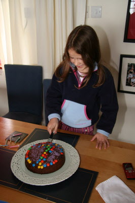 Lottie cutting her cake and making a wish.