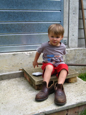 Conrad playing with Grandpa's gardening boots.